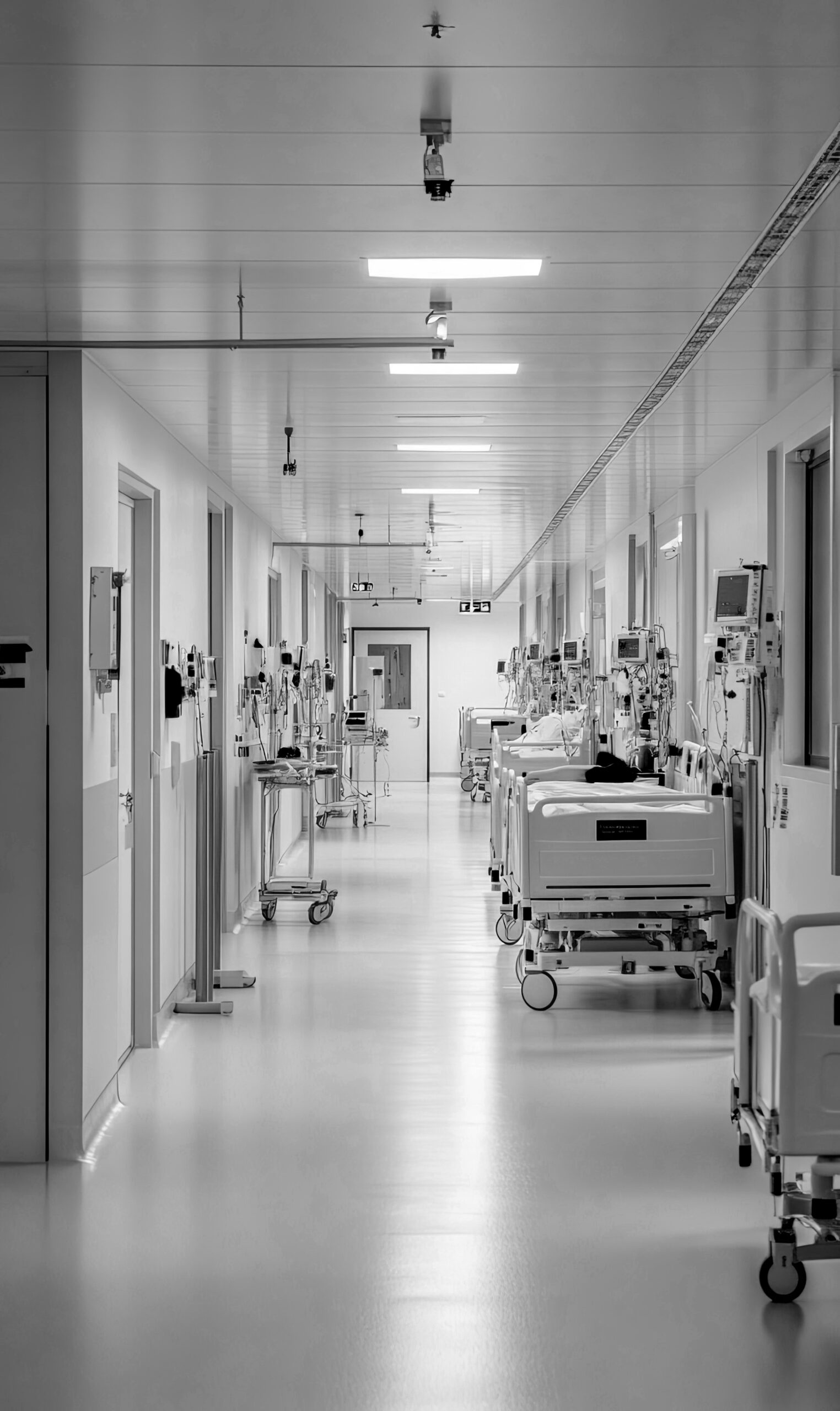 sterile white hospital corridor with multiple beds medical equipment wheels